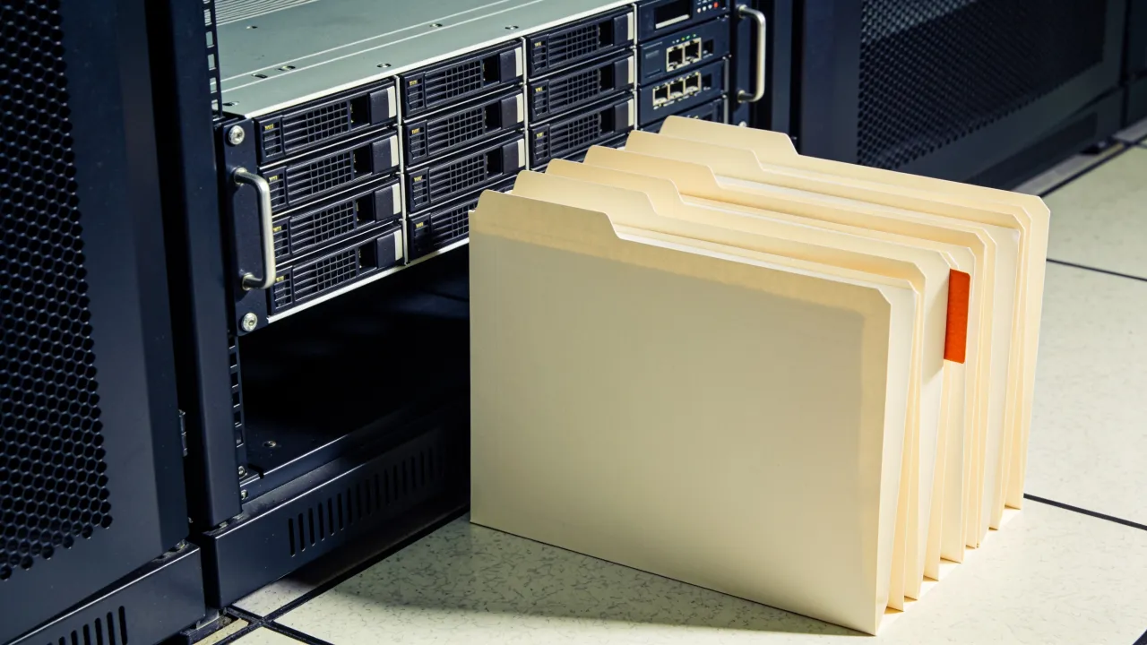 Illustration: blank schema folders beside a server console in a data operations room